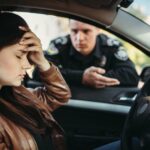 Male cop in uniform check female driver on the road.