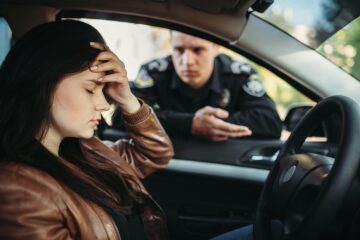 Male cop in uniform check female driver on the road.