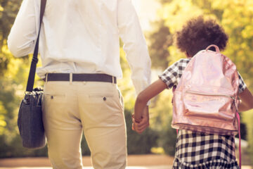 African American father and daughter running trough park. Close up.