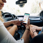 Smiling female driver greeting passenger and accepting new request in car sharing application